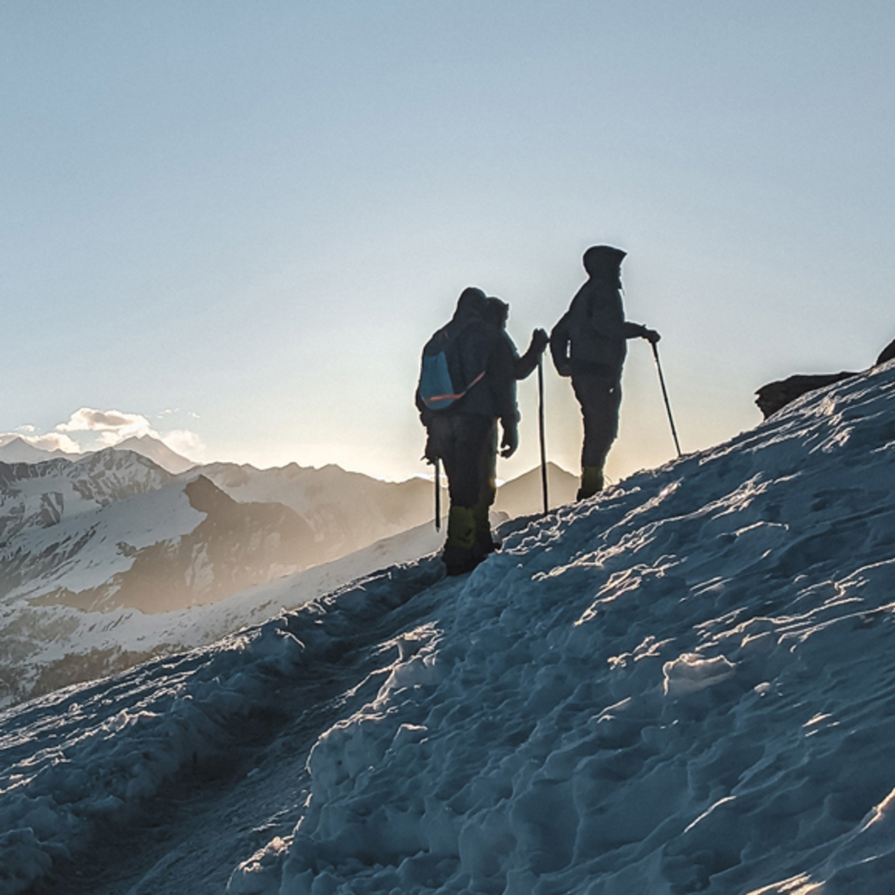 Two people climbing a snowy hill