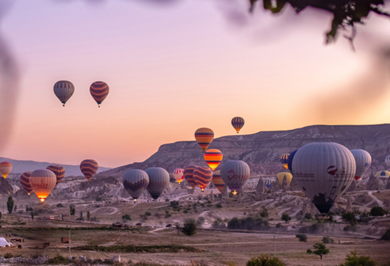Hot air balloons flying over rocky landscape