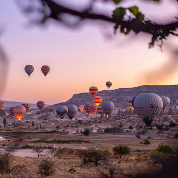 Hot air balloons flying over rocky landscape