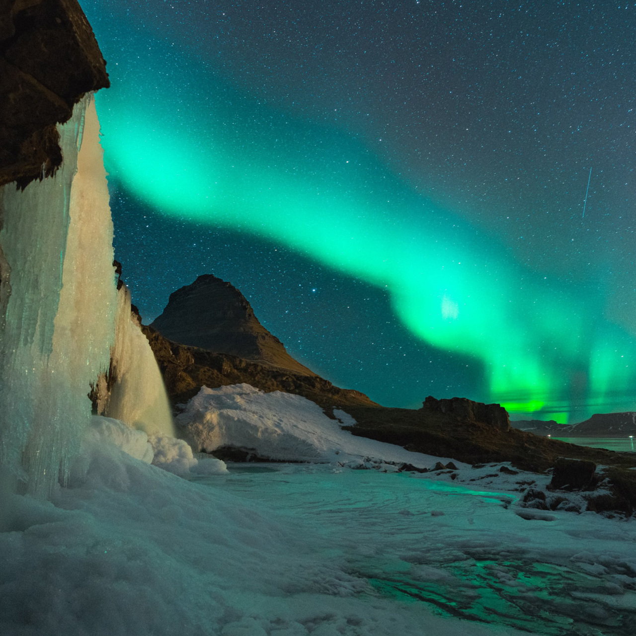 Icy landscape with Northern Lights in sky