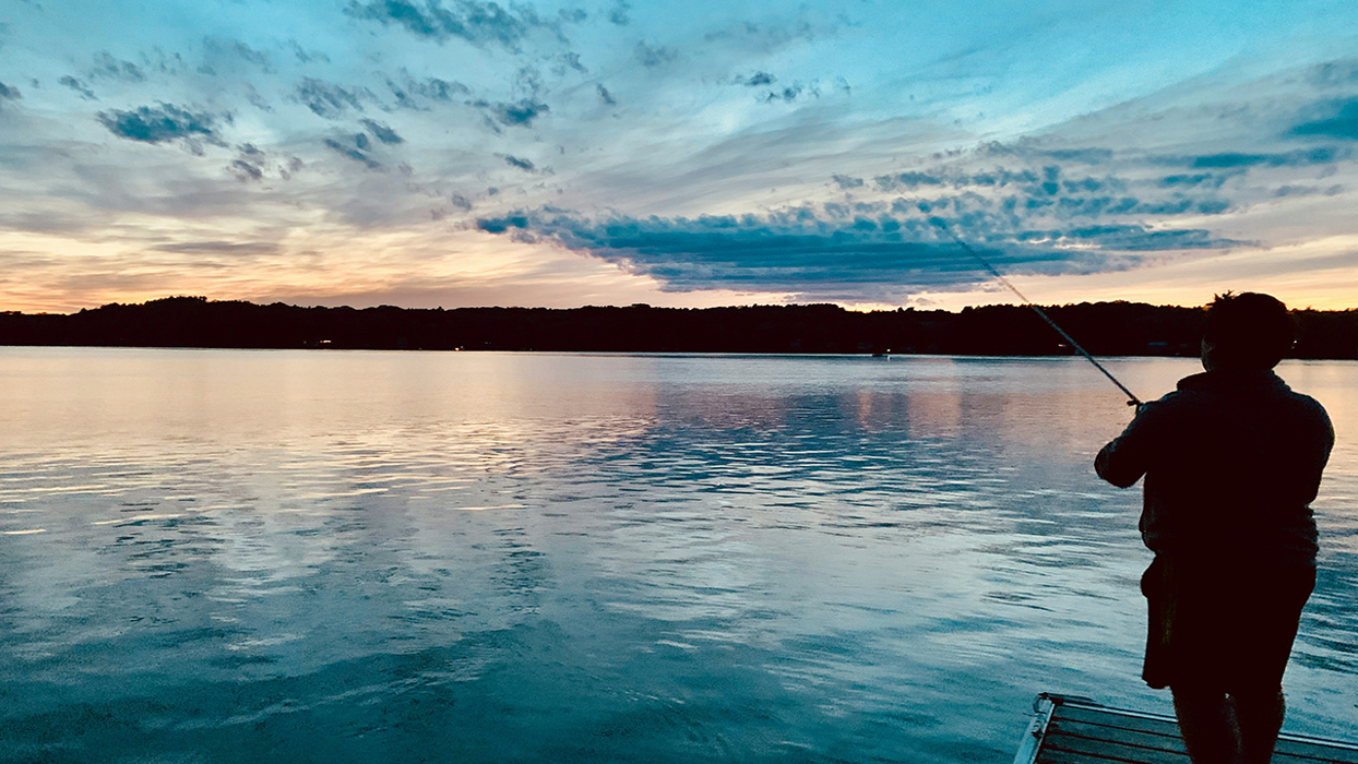 Fisherman on a pier at sunset