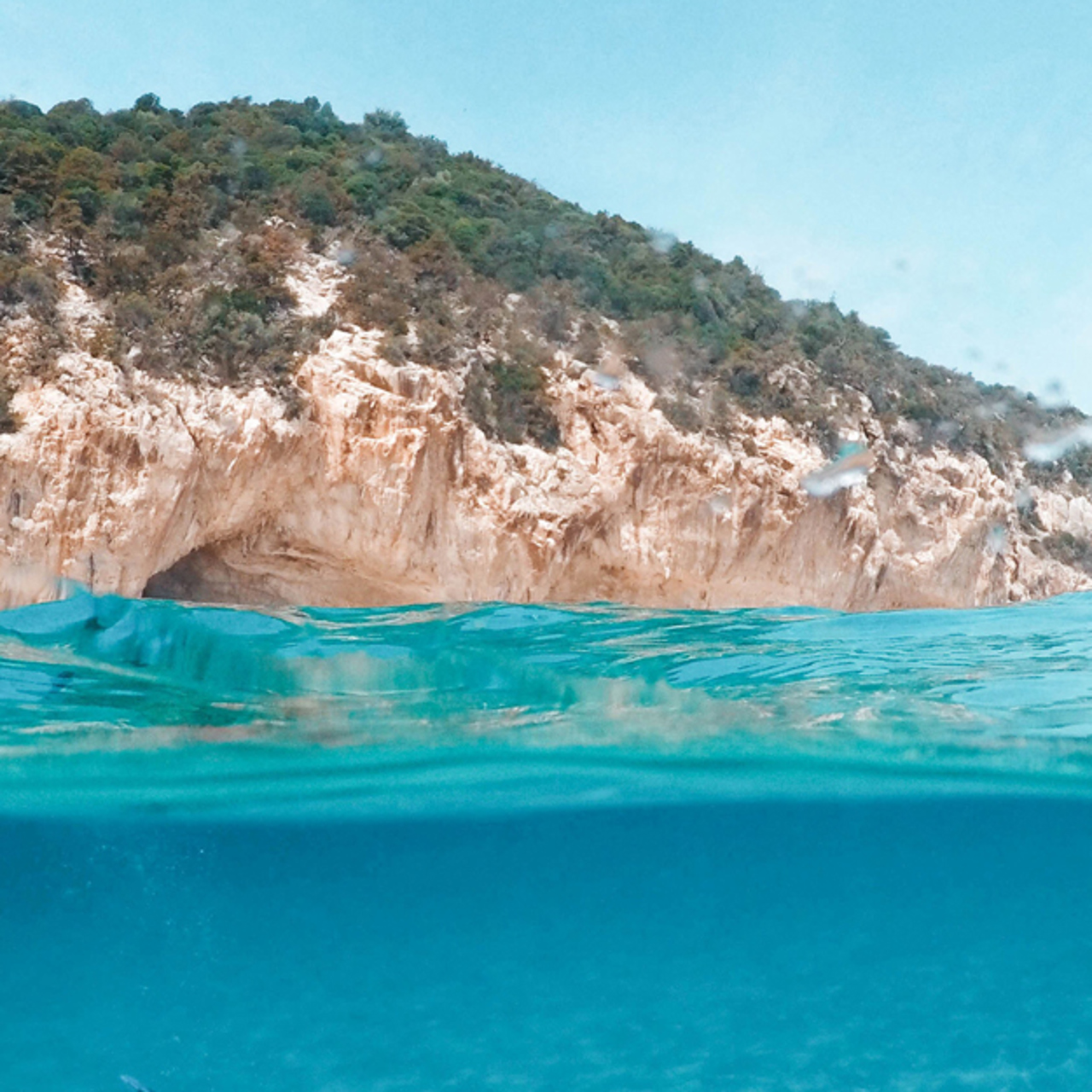 Bright blue water next to a rocky outcrop