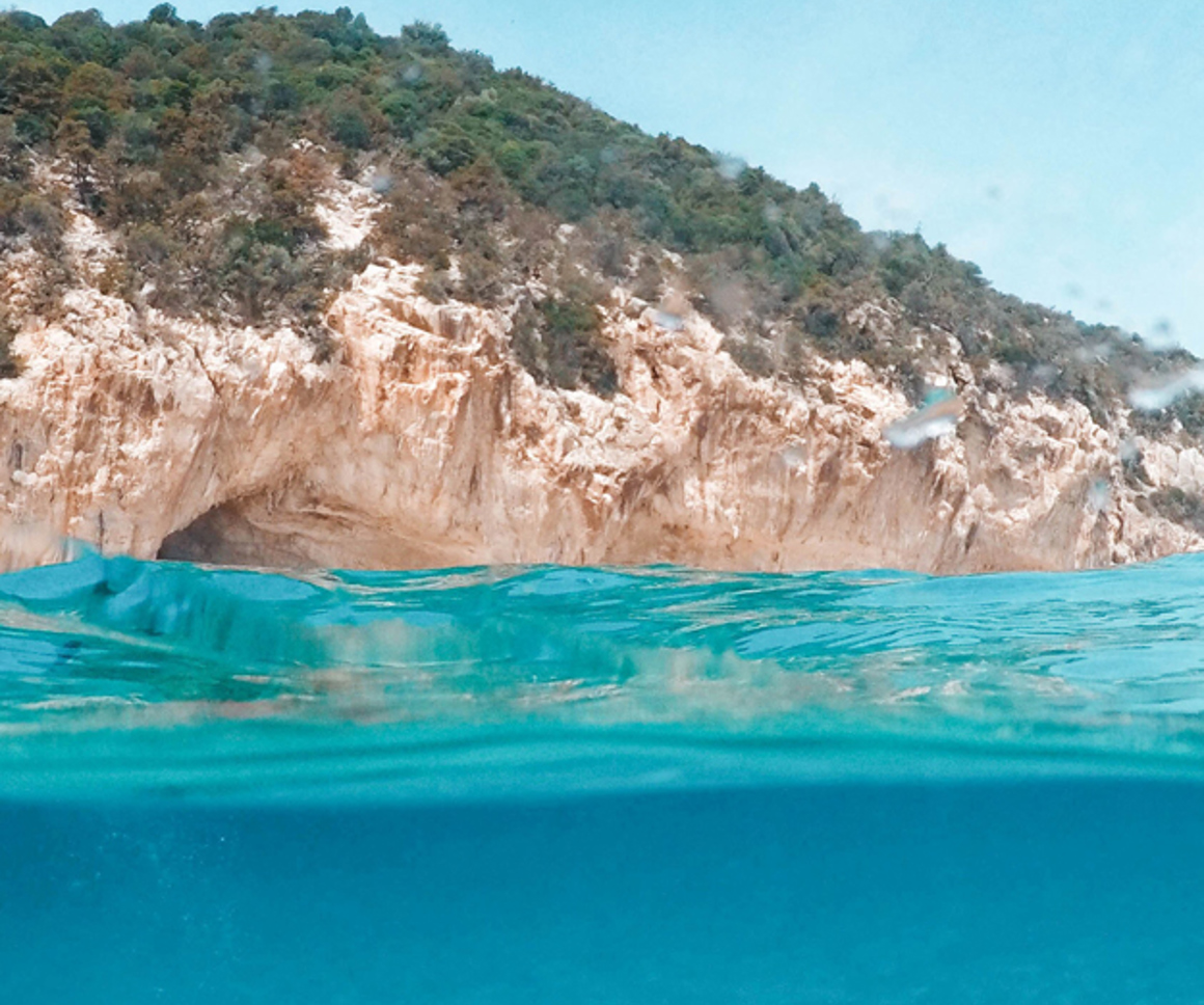 Bright blue water next to a rocky outcrop