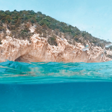 Bright blue water next to a rocky outcrop