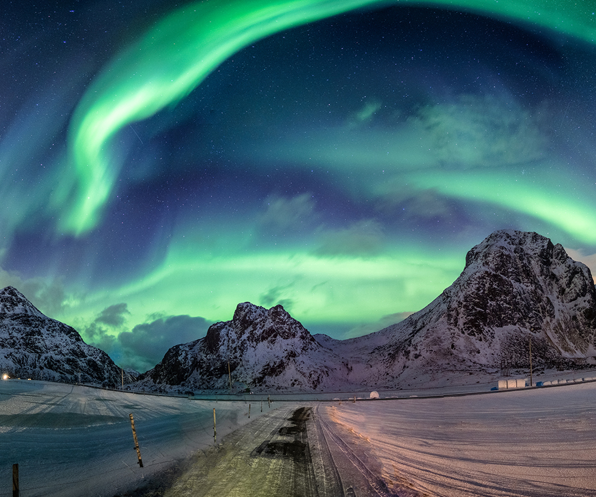 Northern lights over snowy hills