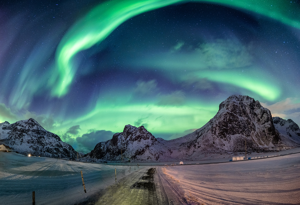Northern lights over snowy hills