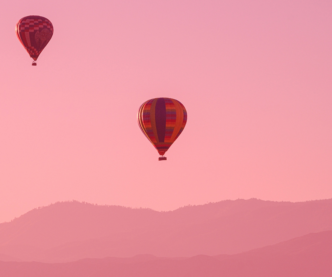 Hot air balloons against pink sky