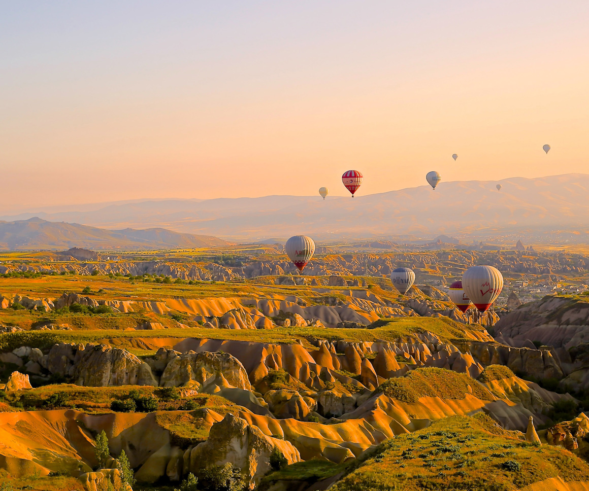 Hot air balloons over rocky valleys