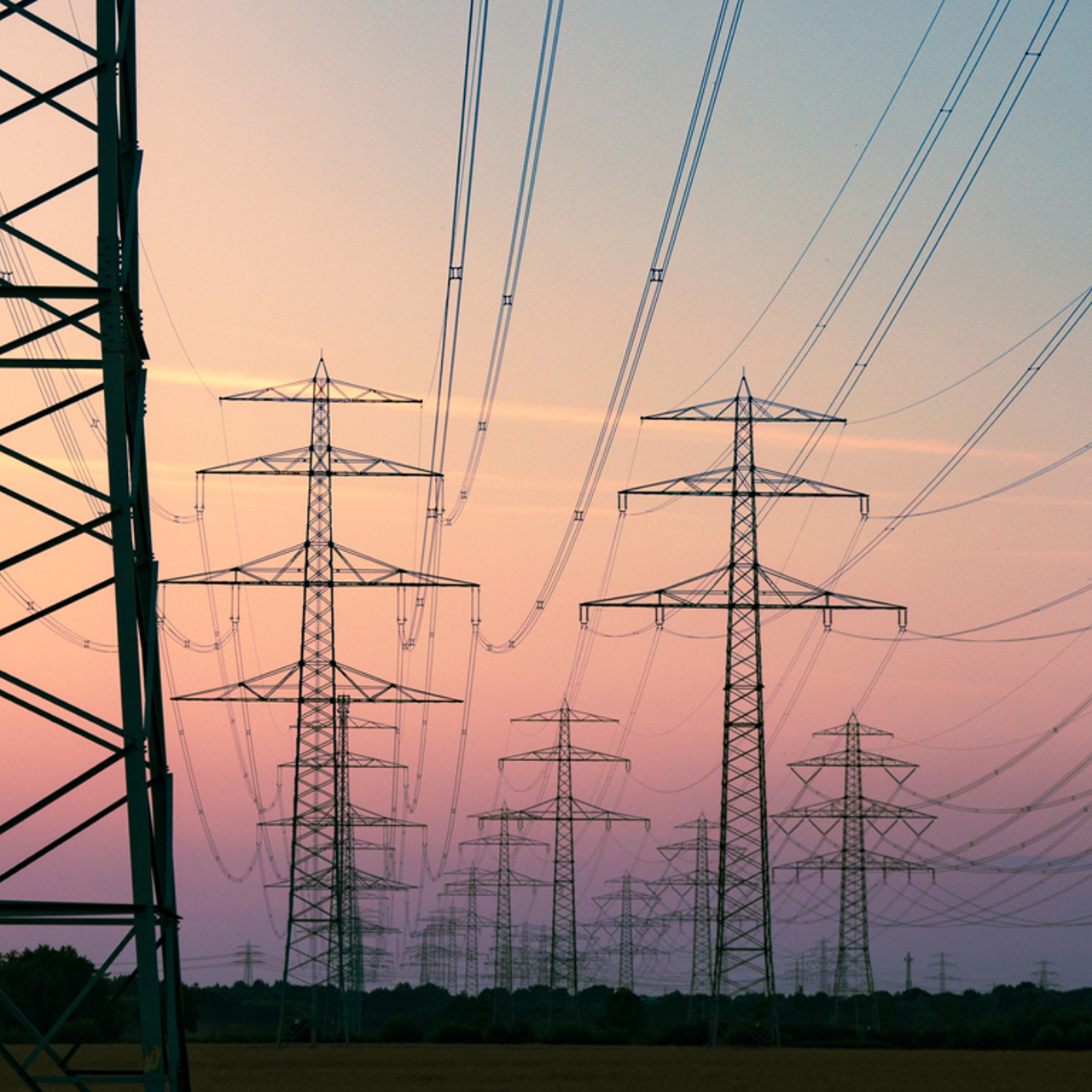 Multiple Transmission Towers Against An Evening Sky
