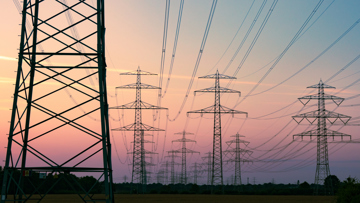 Multiple Transmission Towers Against An Evening Sky