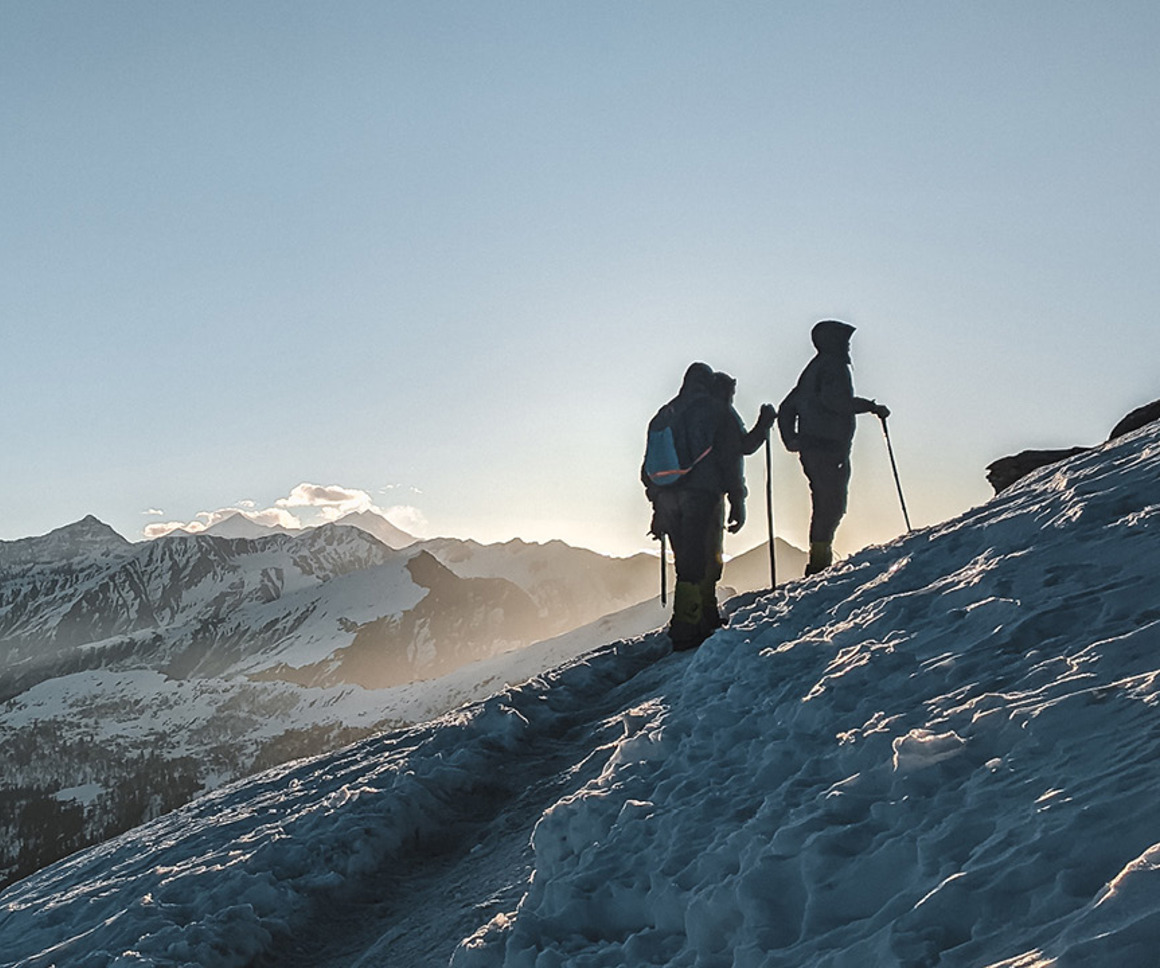 People walking up a snow covered mountain