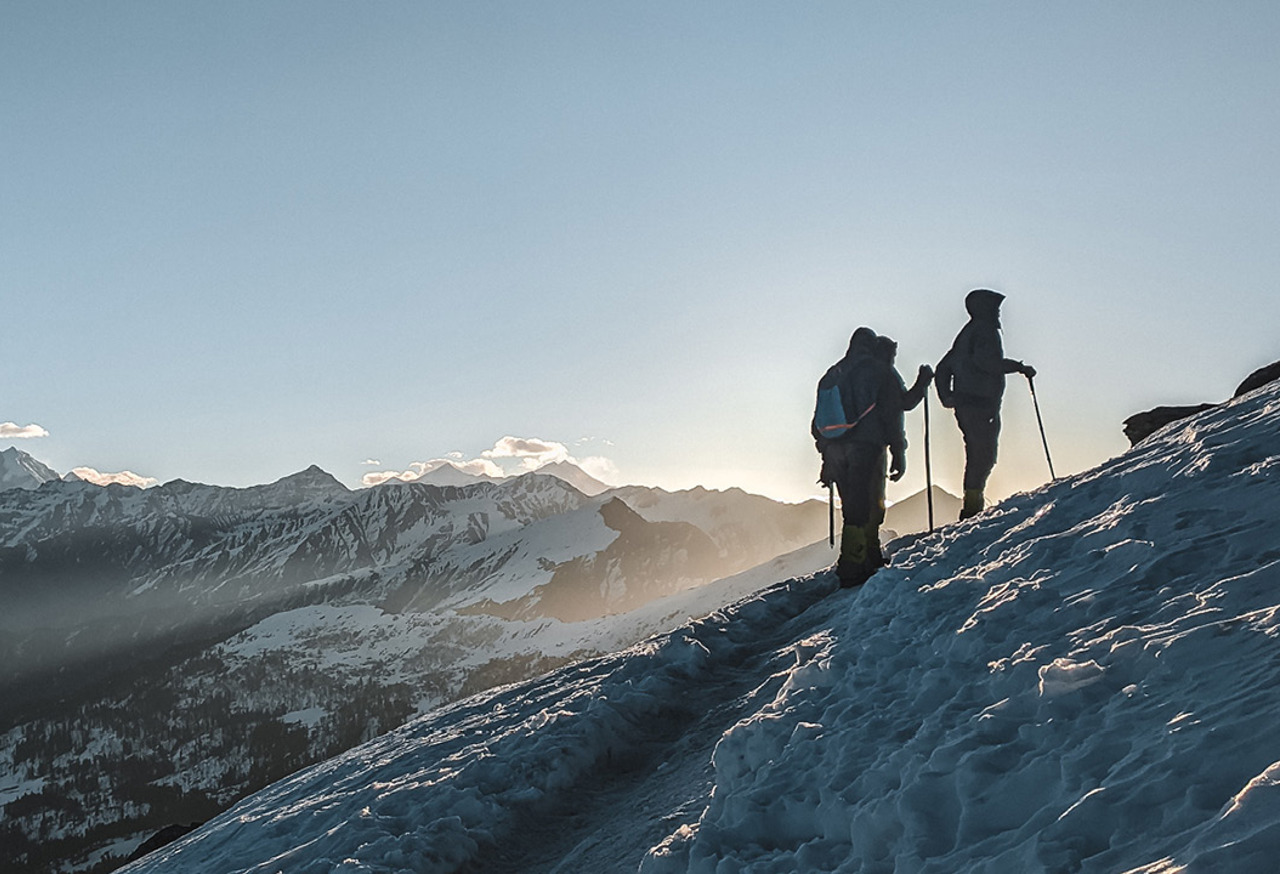 People walking up a snow covered mountain