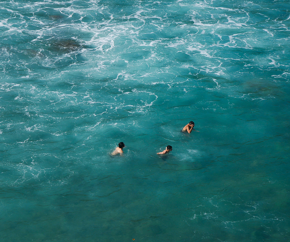 Three people swimming in the sea