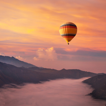 Hot air balloon over misty valley