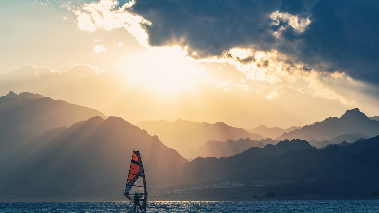 Windsurfing with mountains in the background