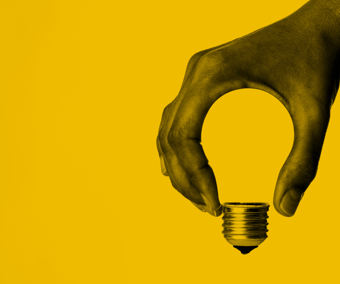 Hand In The Shape Of A Lightbulb On A Yellow Background