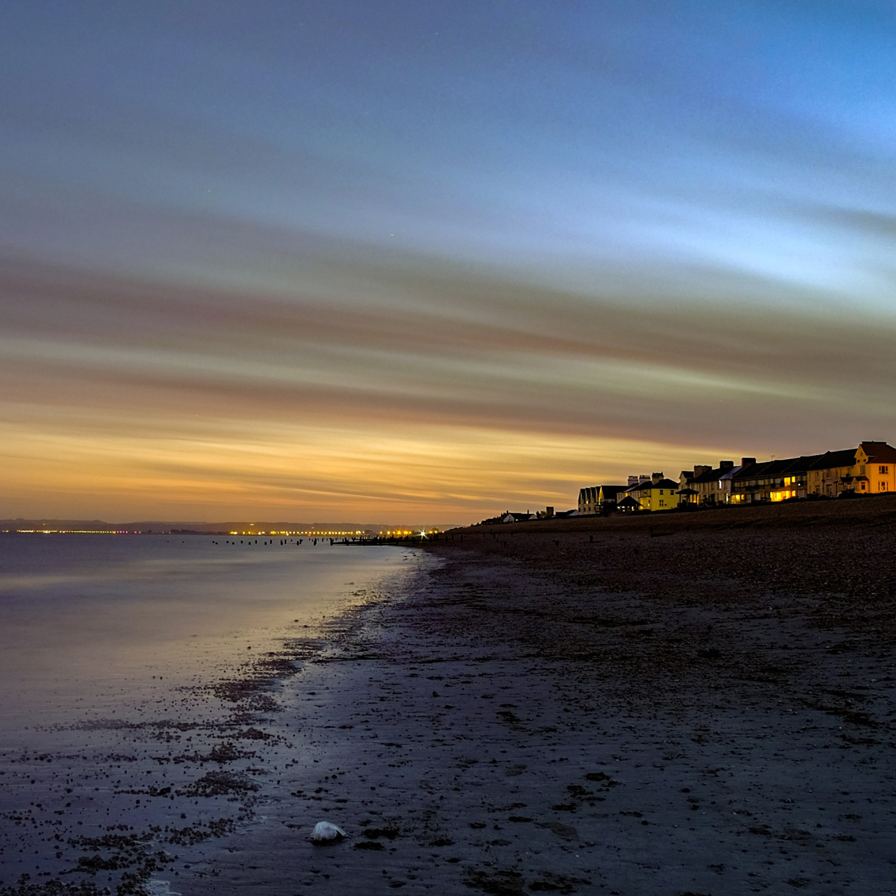 Houses looking out over a beach at sunset