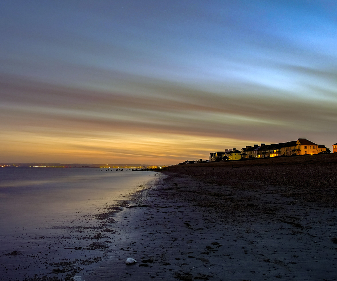 Houses looking out over a beach at sunset