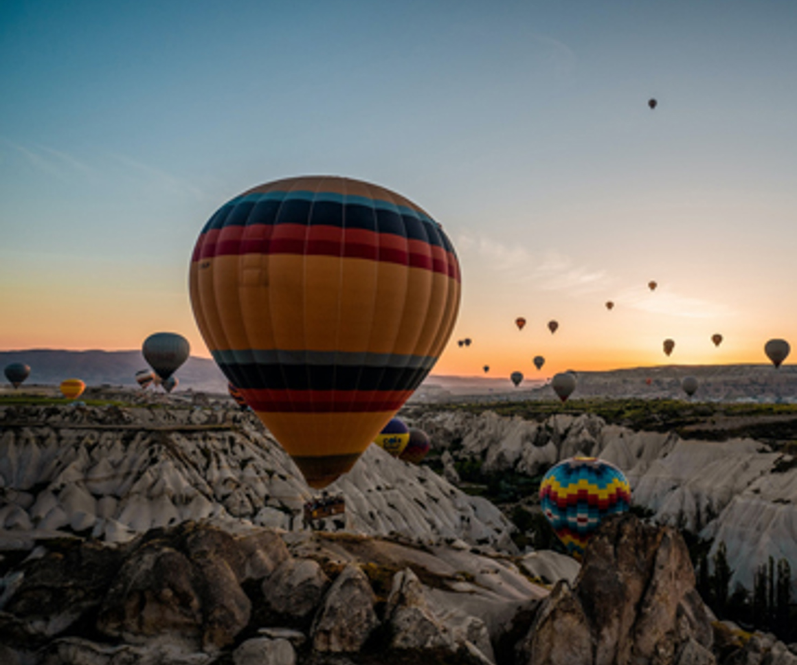 Hot air balloons over rocky valley
