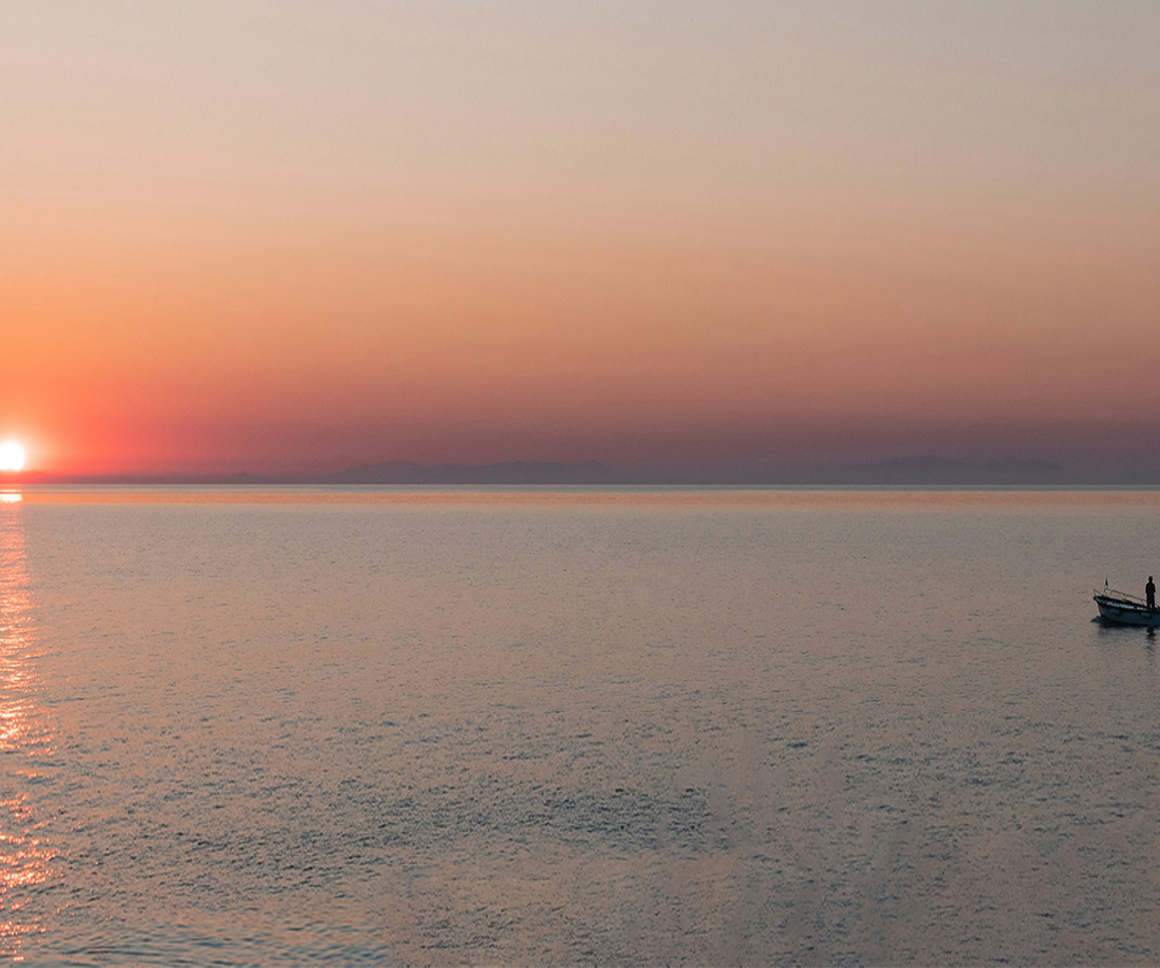 Small boat on water as the sun sets