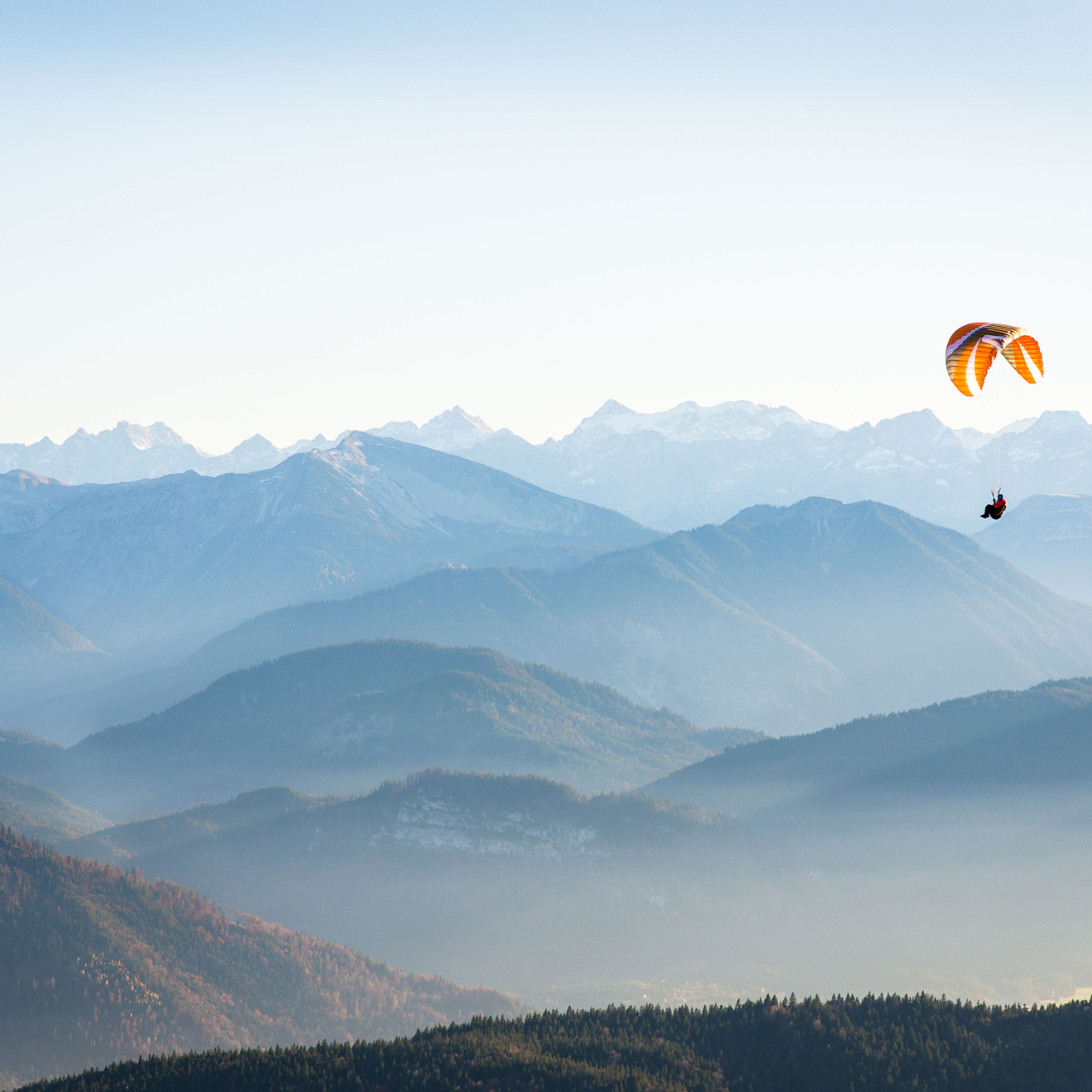 Person Gliding Against A Mountain Backdrop